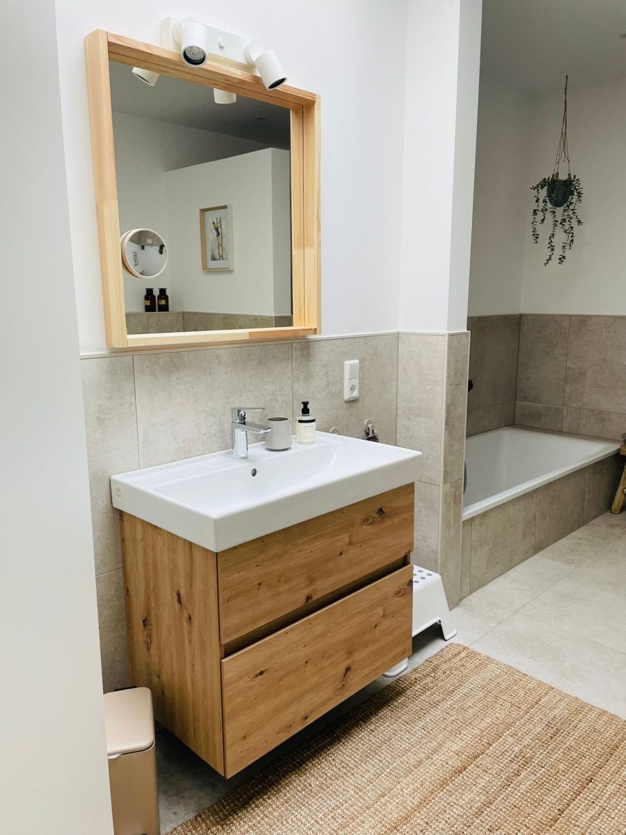 Bad mit Wanne & Dusche Moderne Badezimmeransicht mit Holzwaschtisch, Spiegel und Badewanne.