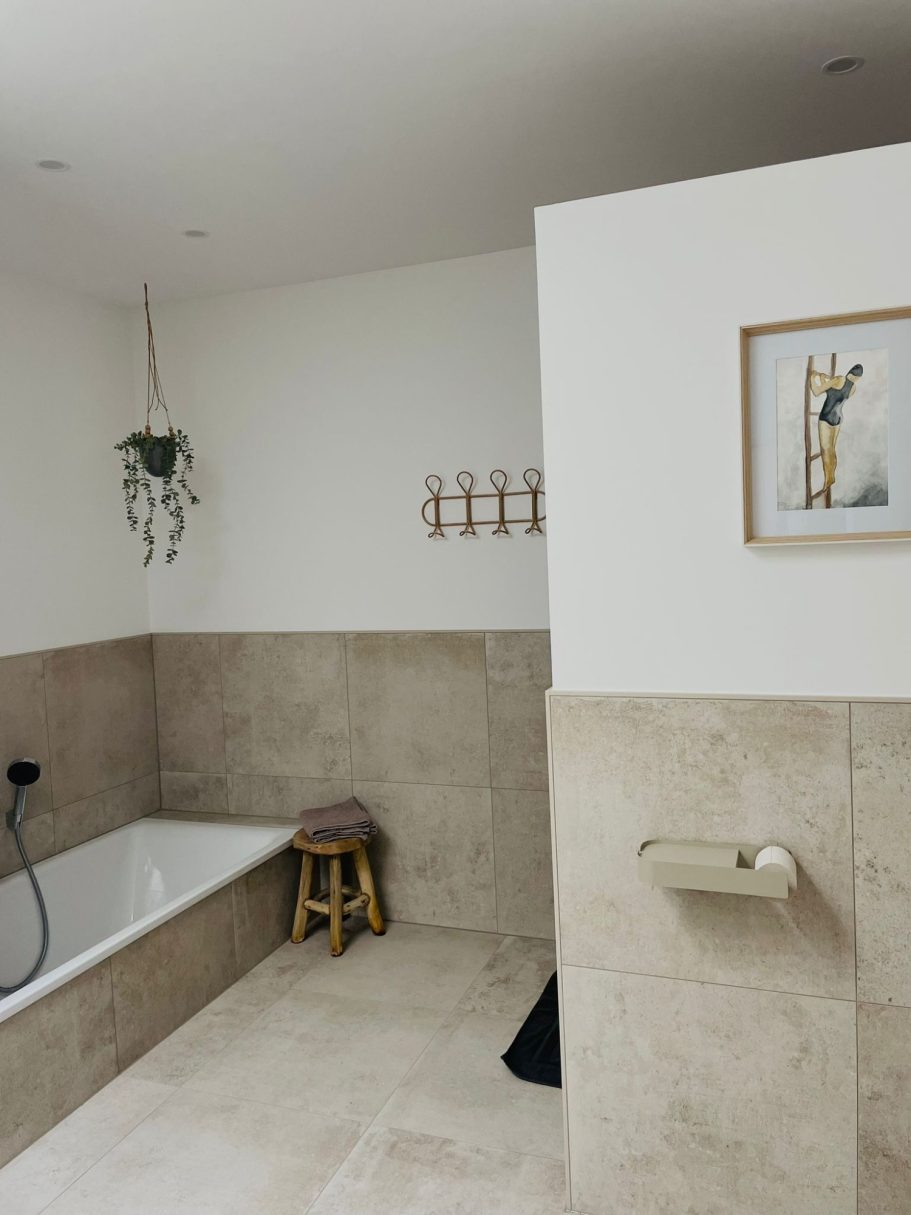 Bad mit Wanne & Dusche Modernes Badezimmer mit Badewanne, Hocker und dekorativen Pflanzen.