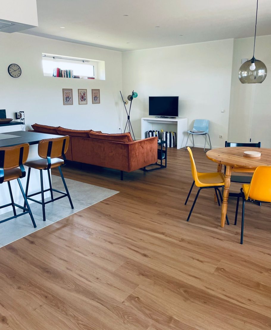 Wohnzimmer mit TV Helles Wohnzimmer mit Sofa, TV, Esstisch und Stühlen in modernem Design.